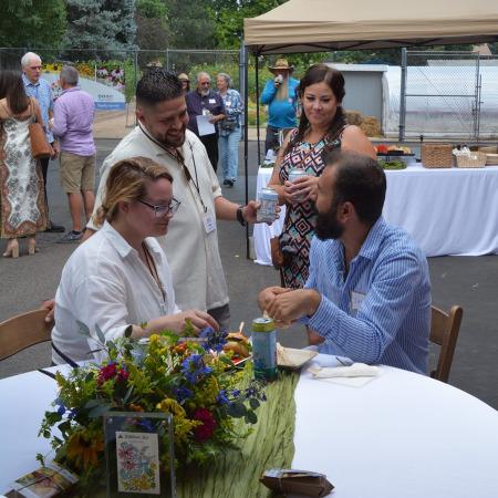 A group of Applewood employees and guests chat excitedly.